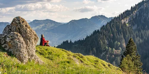 Frau die sich vor Bergpanorama ausruht