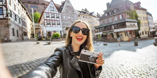 Junge und glückliche Touristin macht Selfie-Foto während ihrer Städtereise in Nürnberg, Deutschland
