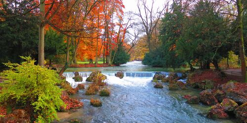 Surfers on the Eisbach river at the Englischer Garten in Munich