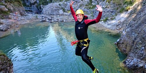 Mann beim Sprung in einen Canyon