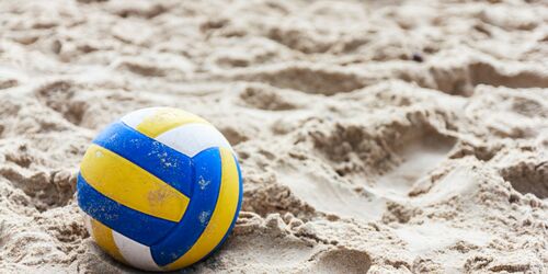 Sand mit gelb, weiß, blauem Volleyball