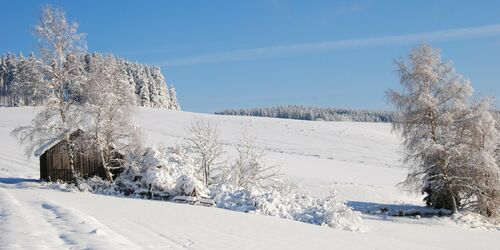 Verschneite Berglandschaft mit einer Hütte