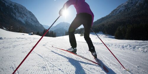 Skilangläufer im Schnee mit Bergpanorama