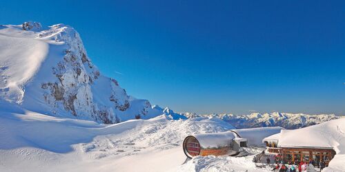 Blick auf das Naturinformationszentrum Karwendel bei Schnee und blauem Himmel