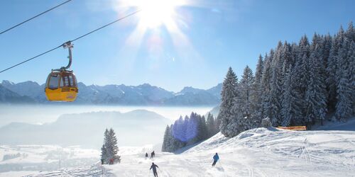 Blick auf die Hörnerbahn mit Schnee und Skifahrern im Hintergrund