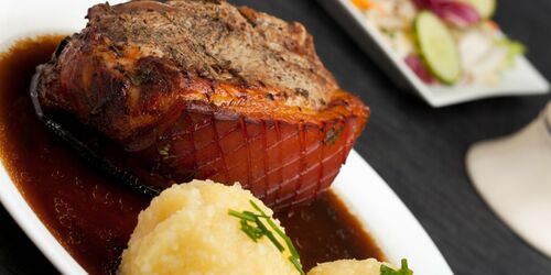 Schweinebraten und Knödel in Soße auf einem Teller