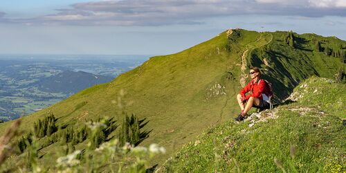 Touring Solo Frau sitzend auf grĂĽn bewachsenem Berg